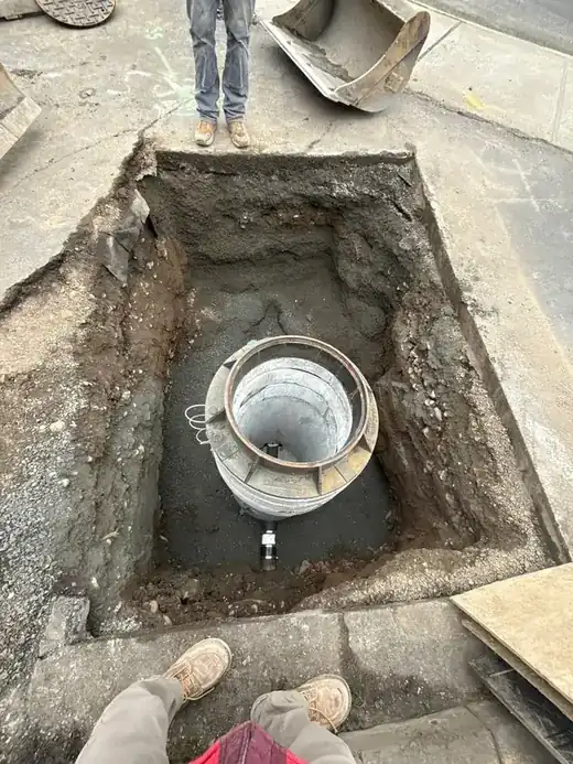 The same excavation seen from above, with the cleanout riser set in gravel