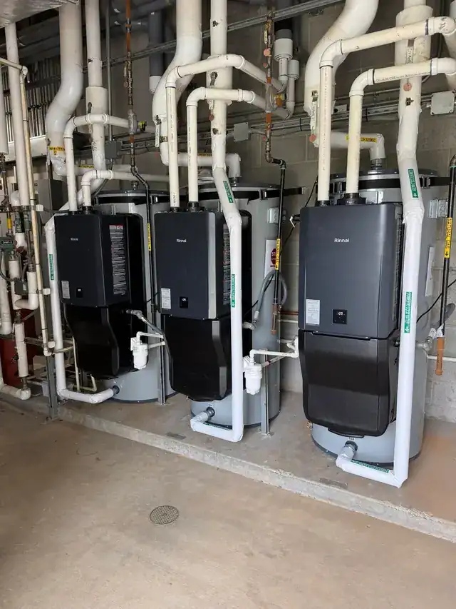 A tighter view of the tankless heater rack and its white insulated piping in a commercial mechanical room
