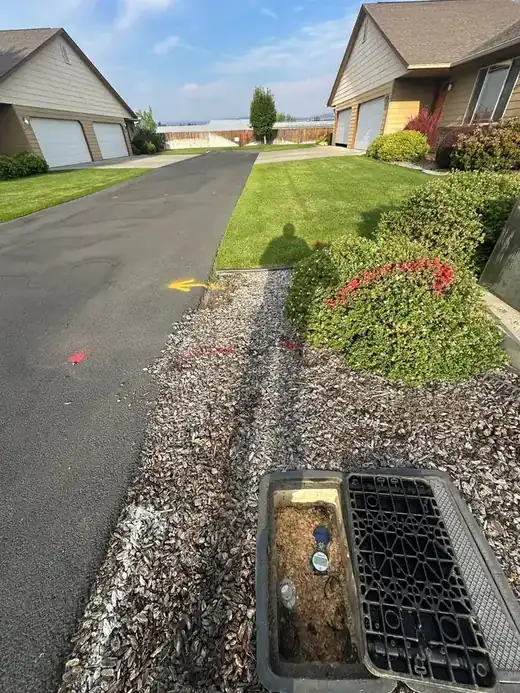 An open water meter box at a residential curb before a line repair