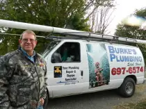Dick Burke standing beside an older white Burke's Plumbing van